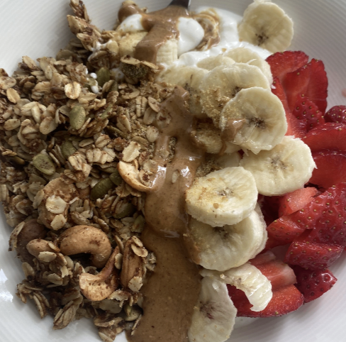 Granola bowl with yoghurt, strawberries, banana and nut butter drizzle