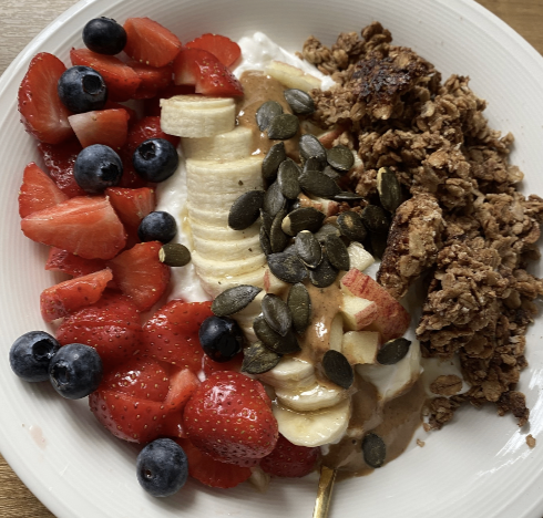 Granola bowl with strawberries, blueberries, banana, pumpkin seeds and nut butter